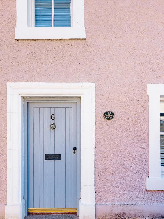 a pink building with a blue door in front at New Haven in Elie