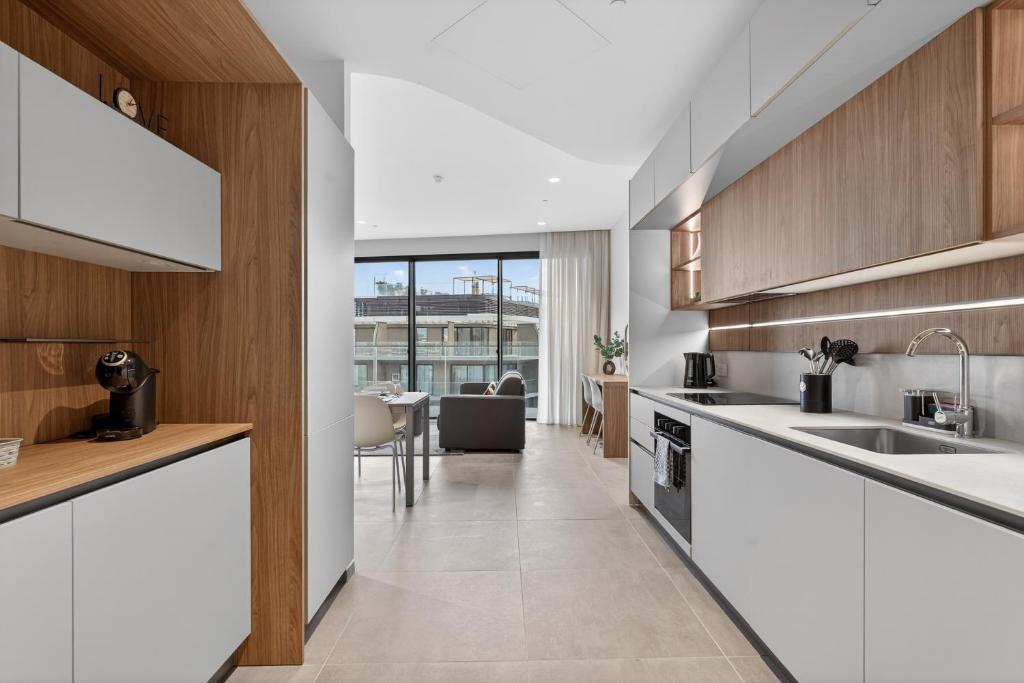 a kitchen with white counters and wooden cabinets at Urban Heights - Apartment in St Julian's in St. Julianʼs