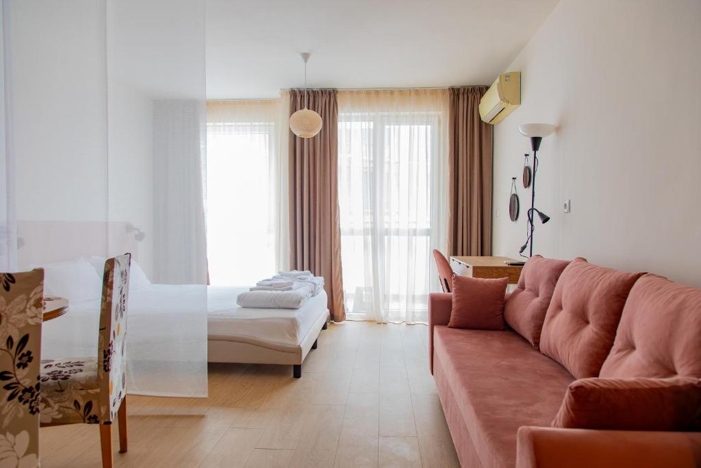 a living room with a couch and a bed at Студио 8 Уютна Почивка in Hisarya