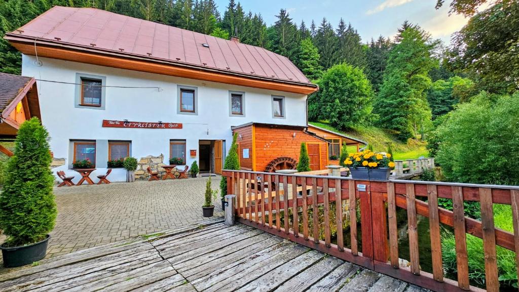 a house with a wooden fence in front of it at Penzion Čtyřlístek in Teplice nad Metují