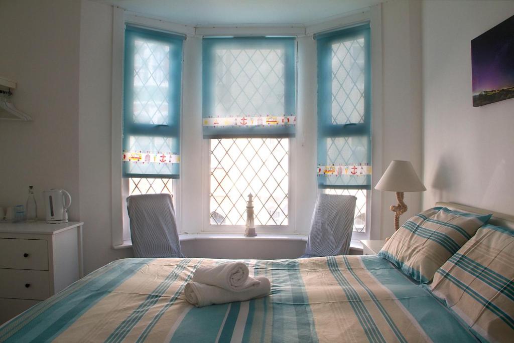 Un dormitorio con una cama con una toalla. en Timrick Lodge, en Weymouth