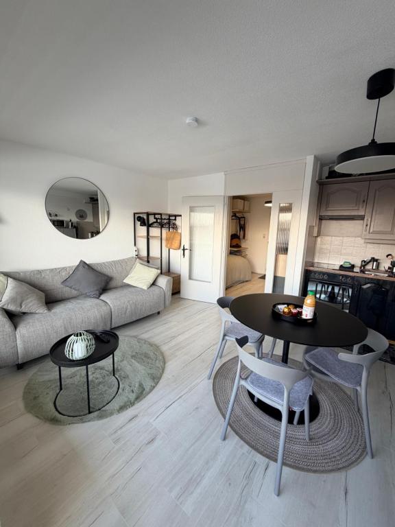 a living room with a couch and a table at Vincenzo appart, Studio Confortable à Nendaz, accès Direct au Télécabine de Tracouet et Parking Souterrain Inclus in Nendaz