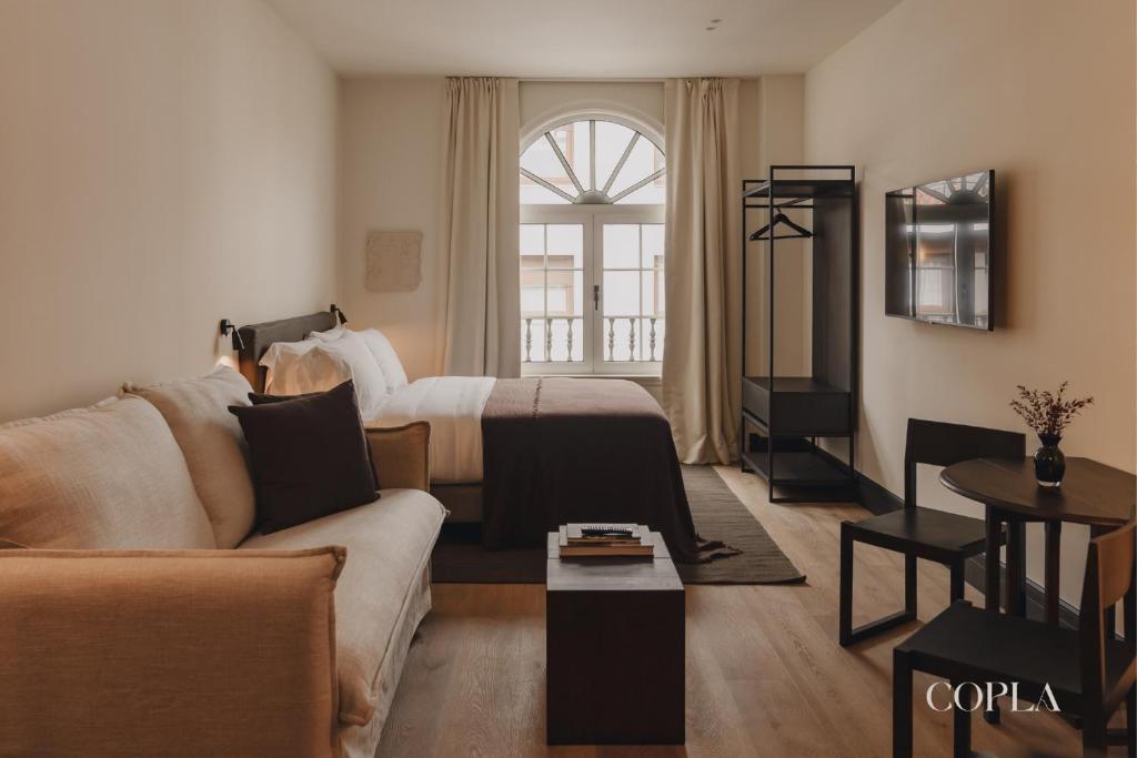 a living room with a bed and a couch at Copla Bilbao in Bilbao