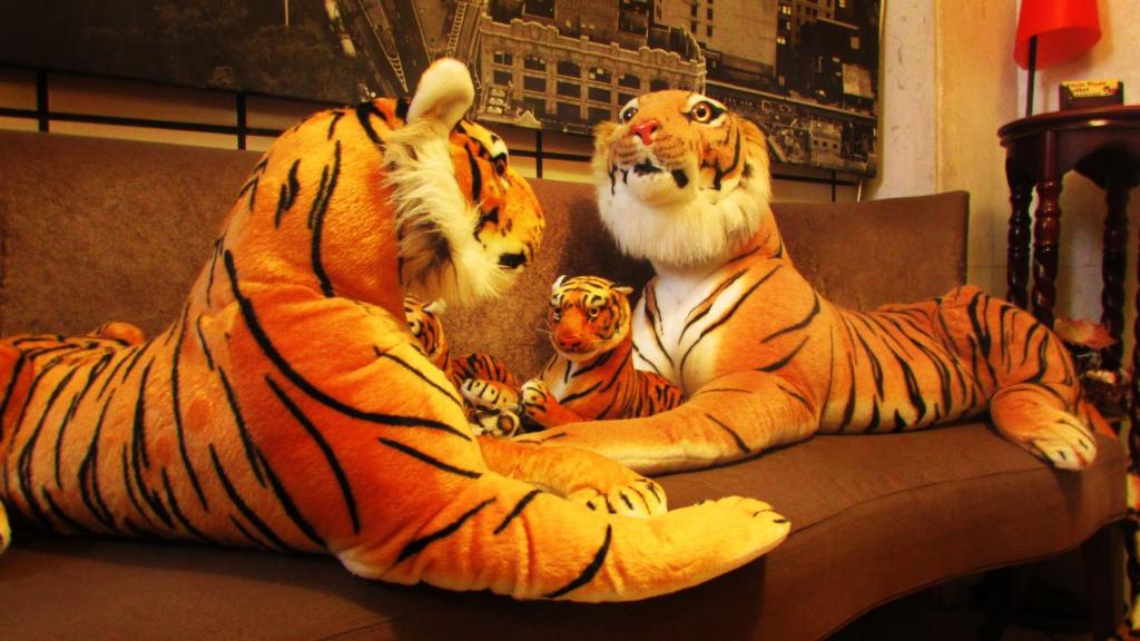two stuffed tigers laying on a couch at Taipei Triple Tiger Inn in Taipei