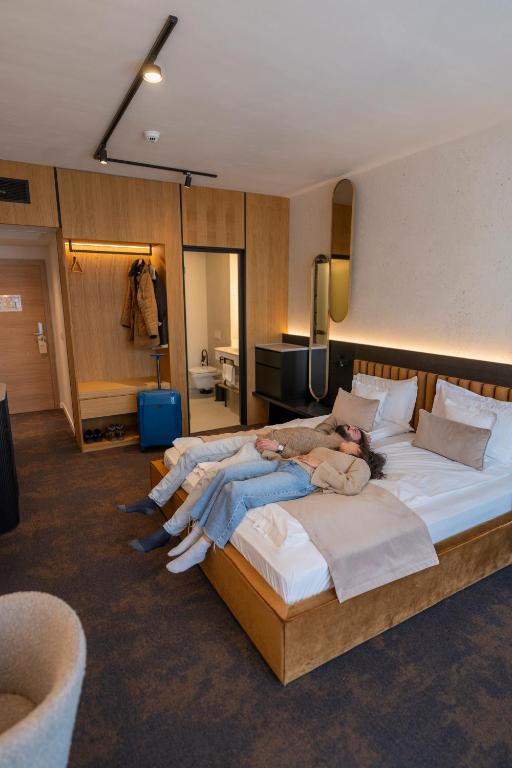 a woman laying on a bed in a hotel room at Element in Alba Iulia
