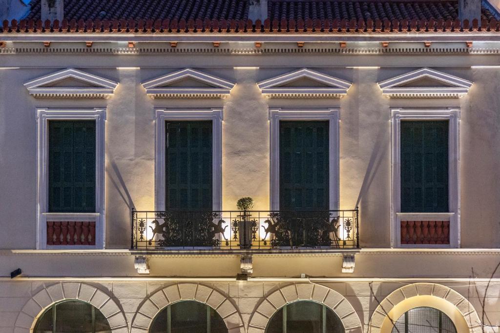 a white building with windows and a balcony at Iliotropio Athens, Thisio in Athens