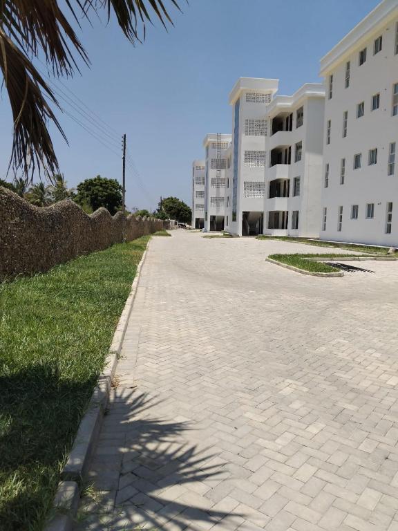 an empty sidewalk in front of a building at Mena apartment in Malindi