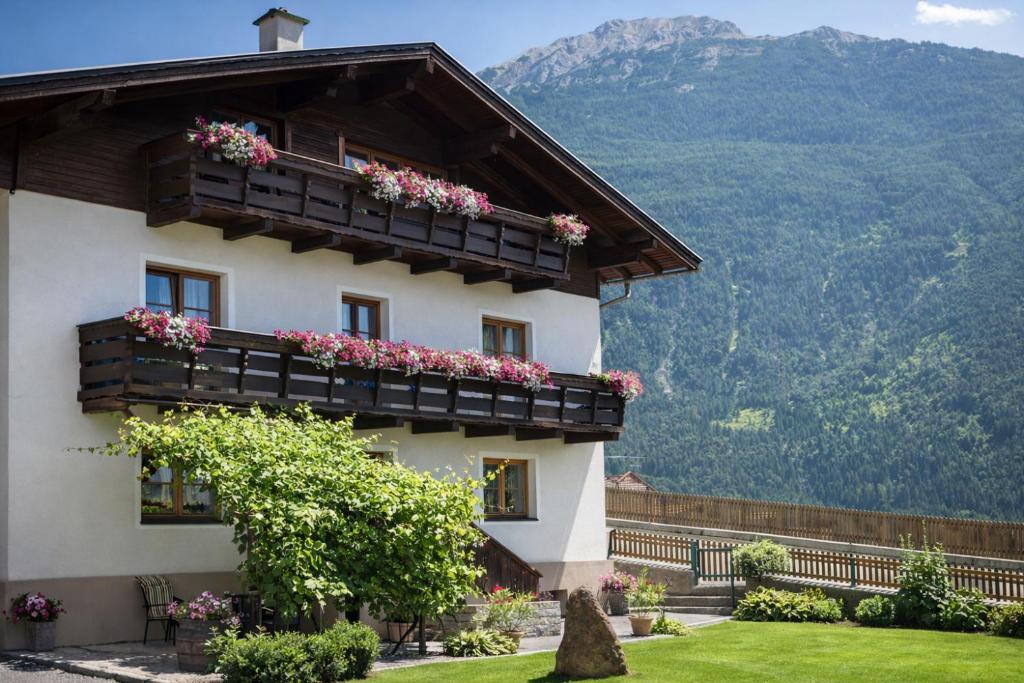 a building with flowers on the balconies with mountains in the background at Apartment Fischer in Tarrenz