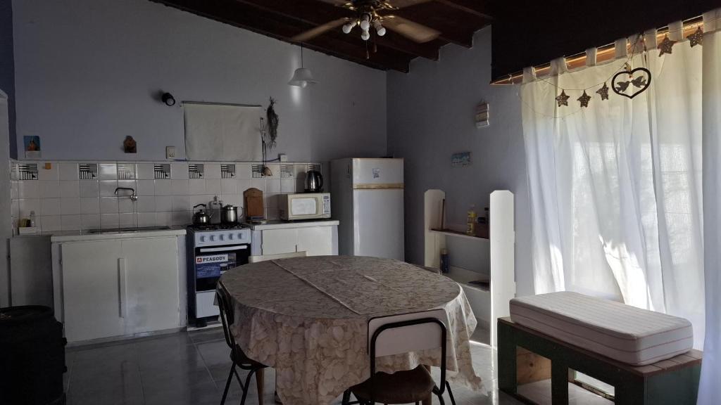 a kitchen with a table and a kitchen with white appliances at Casa en Claromecó in Balneario Claromecó