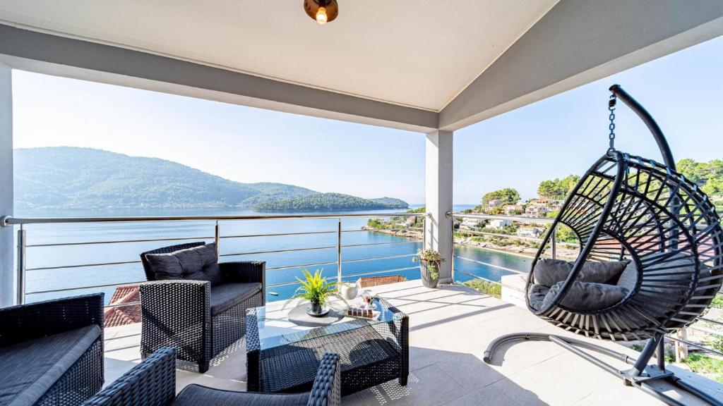 a balcony with a swing and a view of the water at Villa Franka by Villas Guide in Vela Luka