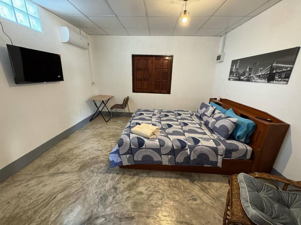 a bedroom with a bed and a flat screen tv at Baboo Studio in Chiang Dao