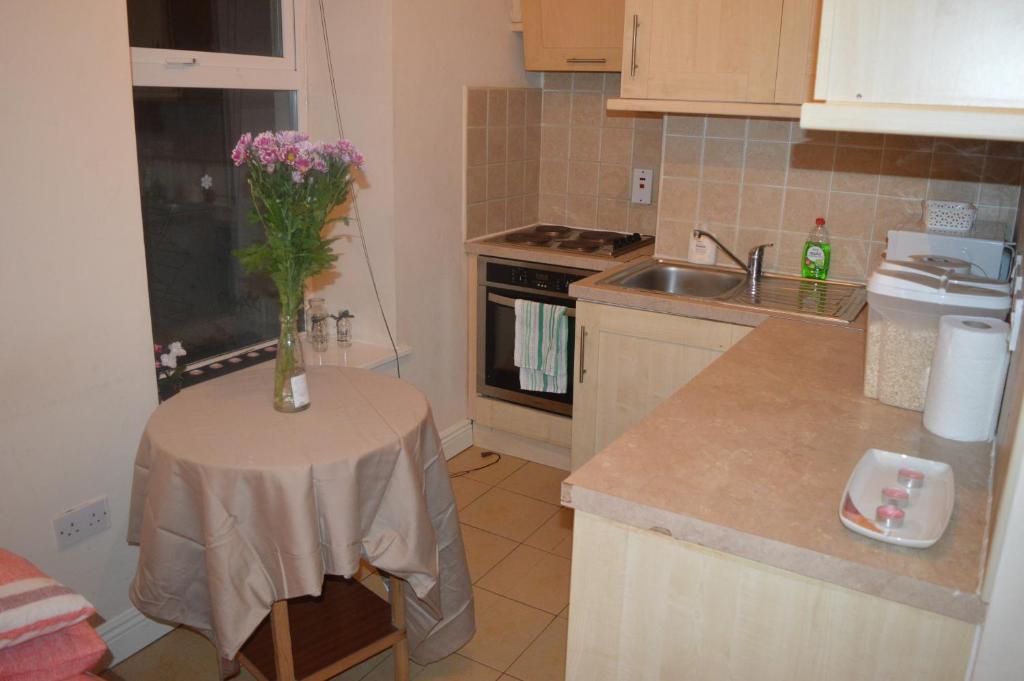 uma cozinha com uma mesa com um vaso de flores em Super Central Dublin Apartments em Dublin