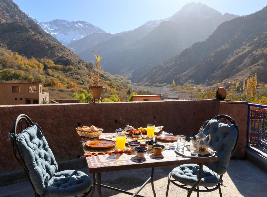 a table on a balcony with a view of mountains at Eagle Lodge in Imlil