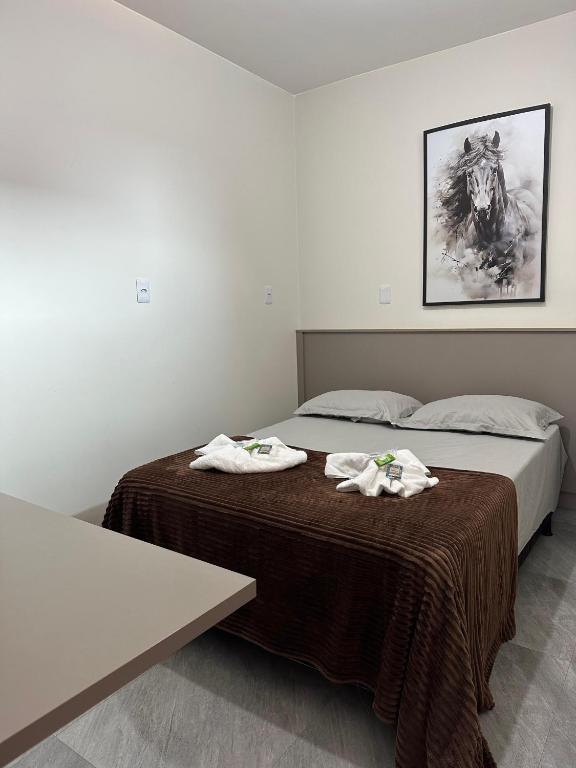 a bedroom with two beds with towels on them at Suíte Cavalos - Queen's Hotel in Formosa