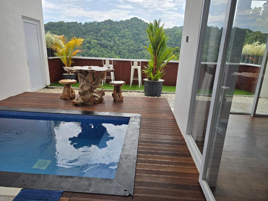 a patio with a pool and a table on a deck at Probosiwi Resort Syariah in Talunombo