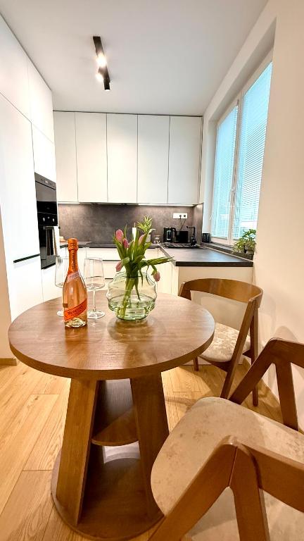 a kitchen with a wooden table with a vase of flowers on it at Prosperity Apartment s parkovaním in Žilina