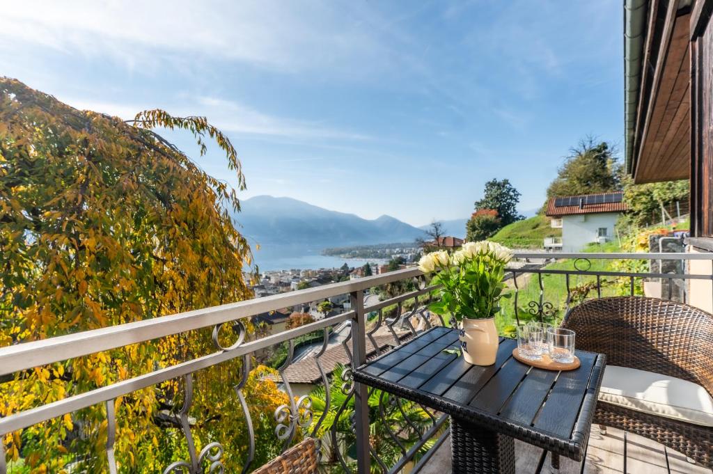 a table on a balcony with a view at Casa Sybille, beautiful lake view in Minusio