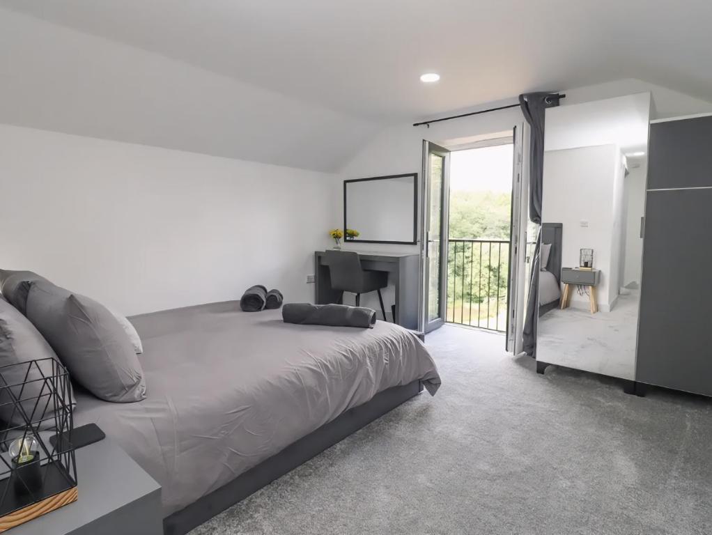 a bedroom with a bed and a desk and a window at The View - Peaceful Duplex Apartment with Views, Parking & Wifi in Nuneaton
