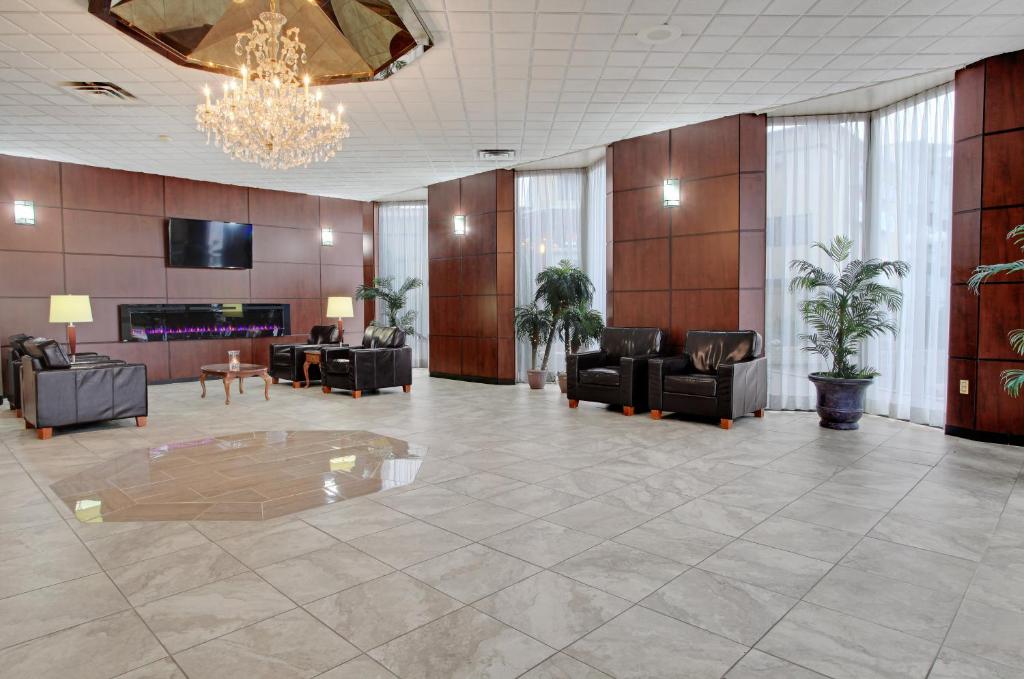a lobby with couches and chairs and a chandelier at Travelodge by Wyndham Lloydminster in Lloydminster
