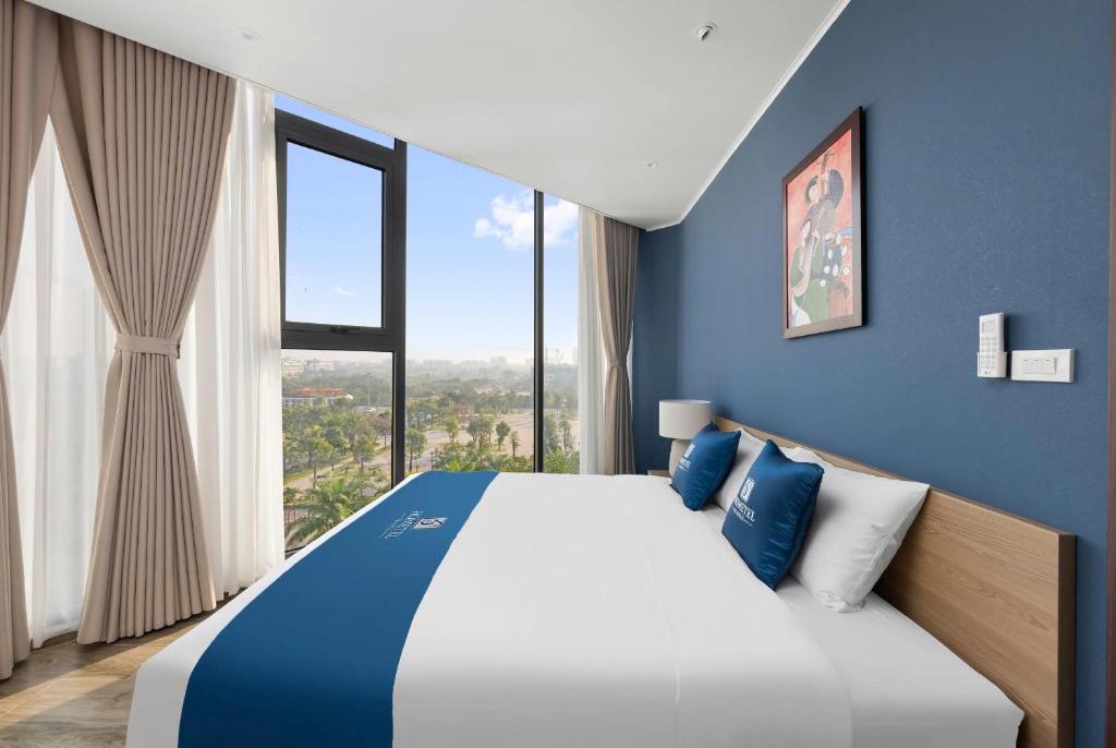 a blue bedroom with a large bed with a large window at 3A Hometel Hanoi in Hanoi