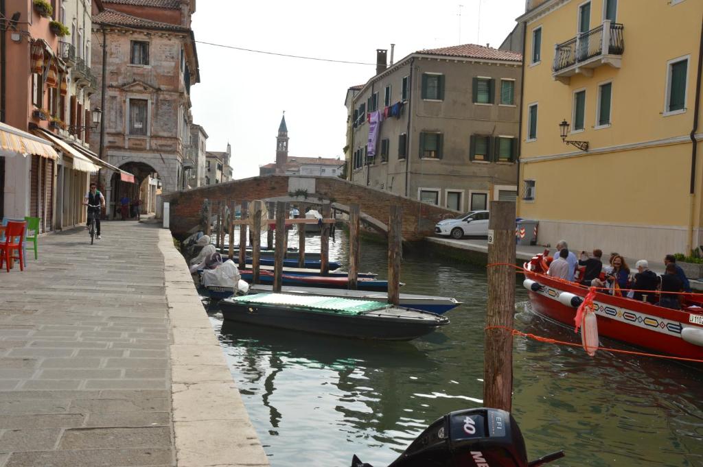 a group of boats are docked in a canal at Hotel del Mar in Sottomarina