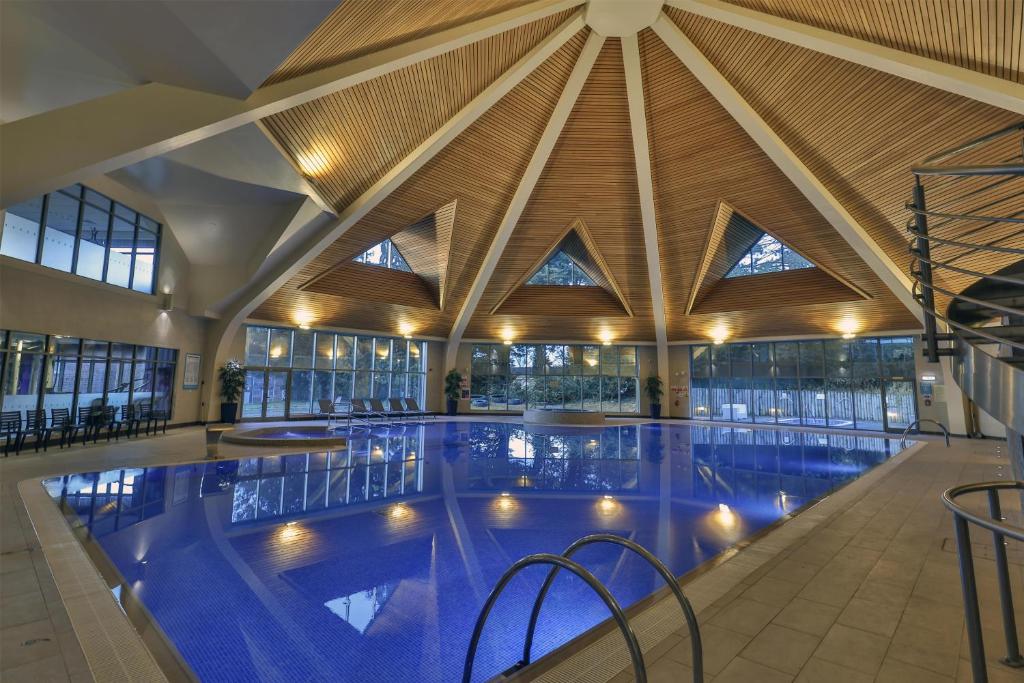 a large indoor swimming pool with a wooden ceiling at Best Western Plus Kenwick Park Hotel in Louth
