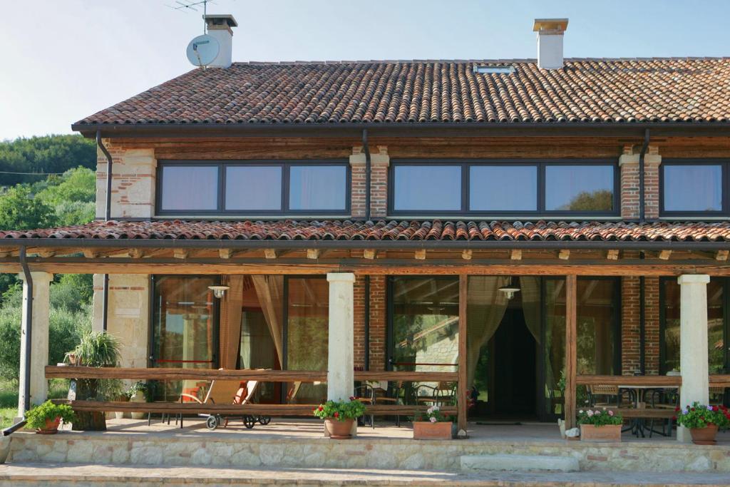 a house with a bench in front of it at Agriturismo Monte degli Aromi in Villaga