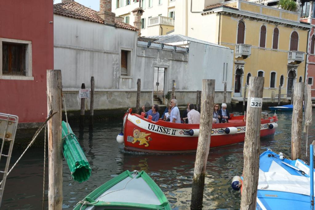 a group of people on a boat in a canal at Hotel del Mar in Sottomarina
