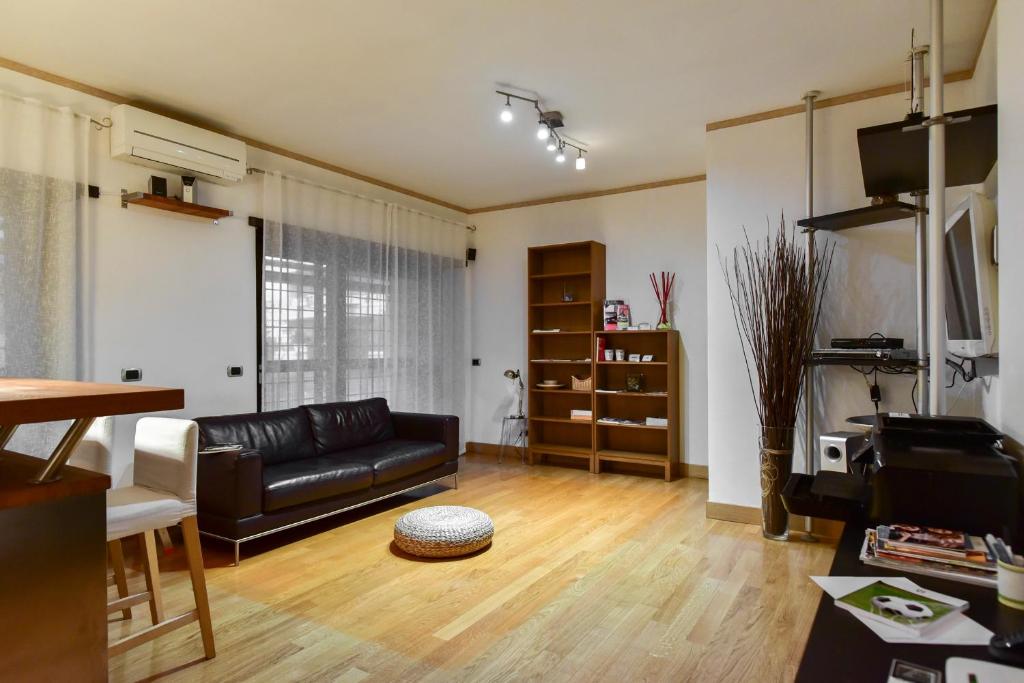 salon z czarną skórzaną kanapą i telewizorem w obiekcie Home Sorbara "Luxury Home" w Rzymie