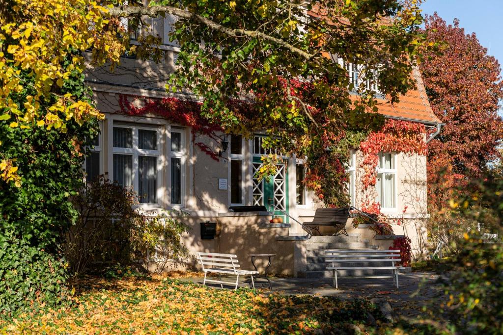a house with two benches in front of it at Gutshaus Barkow in Barkhagen