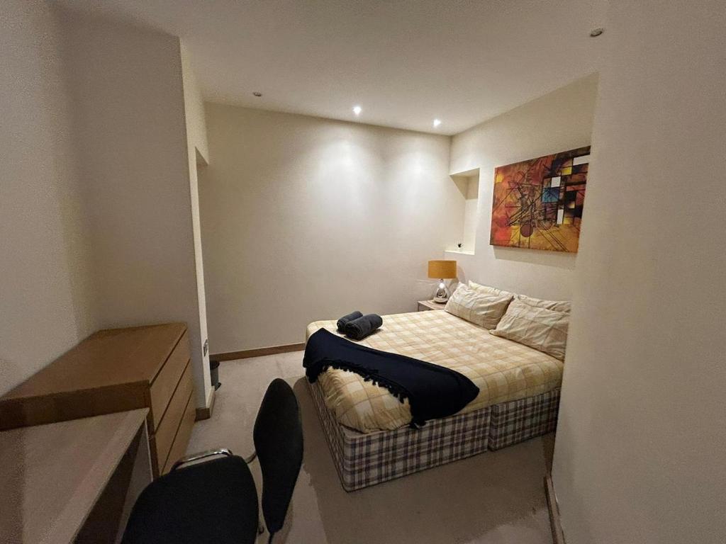 a small bedroom with a bed and two chairs at Sunderland City Cozy Flat in Sunderland