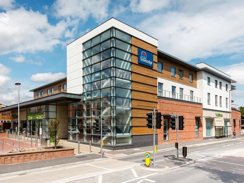 a building on a street with a traffic light at Travelodge Egham in Egham