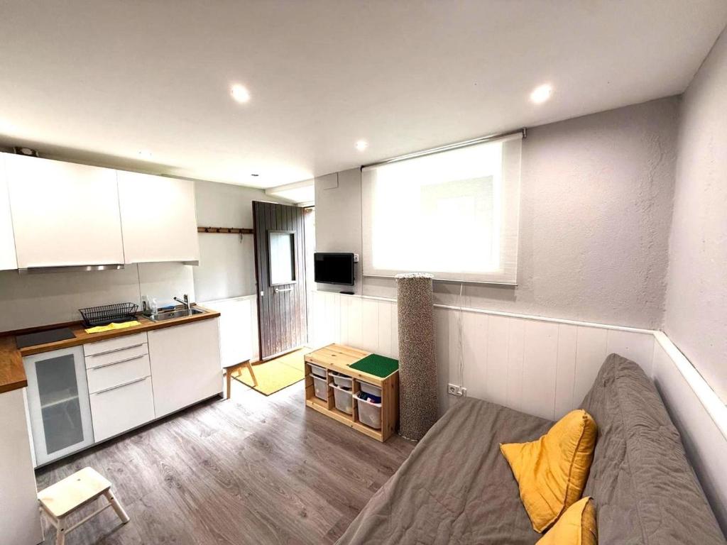 a living room with a couch and a kitchen at Loft 4 personas en La Molina in La Molina