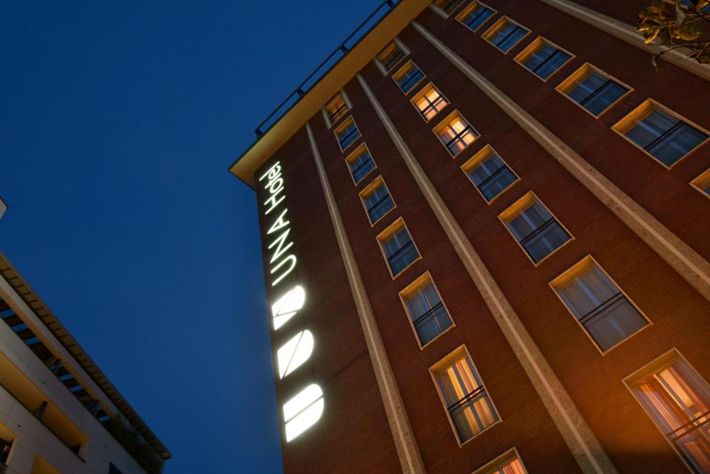a building with a sign on the side of it at UNA Hotels Mediterraneo Milano in Milan