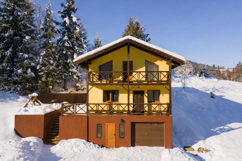 a house in the snow with a balcony at Yellow House in Pilipets