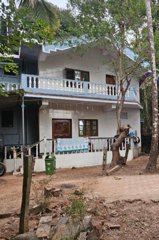 a white house with a tree in front of it at Villa westcost tembewadda colomb in Canacona