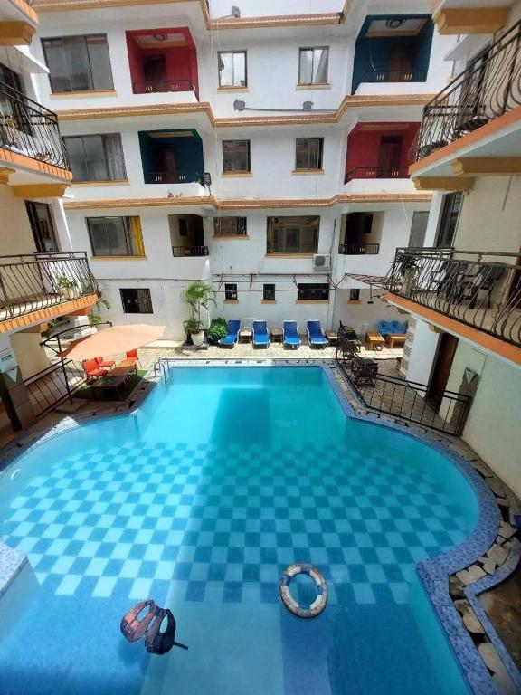 a large swimming pool in front of a building at Bliss Residence Studio Mtwapa in Mtwapa