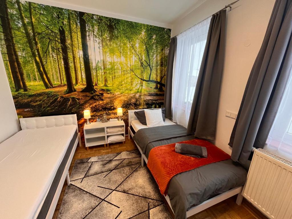 a bedroom with two beds and a mural of a forest at Großes Apartment Aschaffenburg 4 Schlafzimmer bis zu 10 Personen Mainpark Apartment Mainaschaff in Mainaschaff