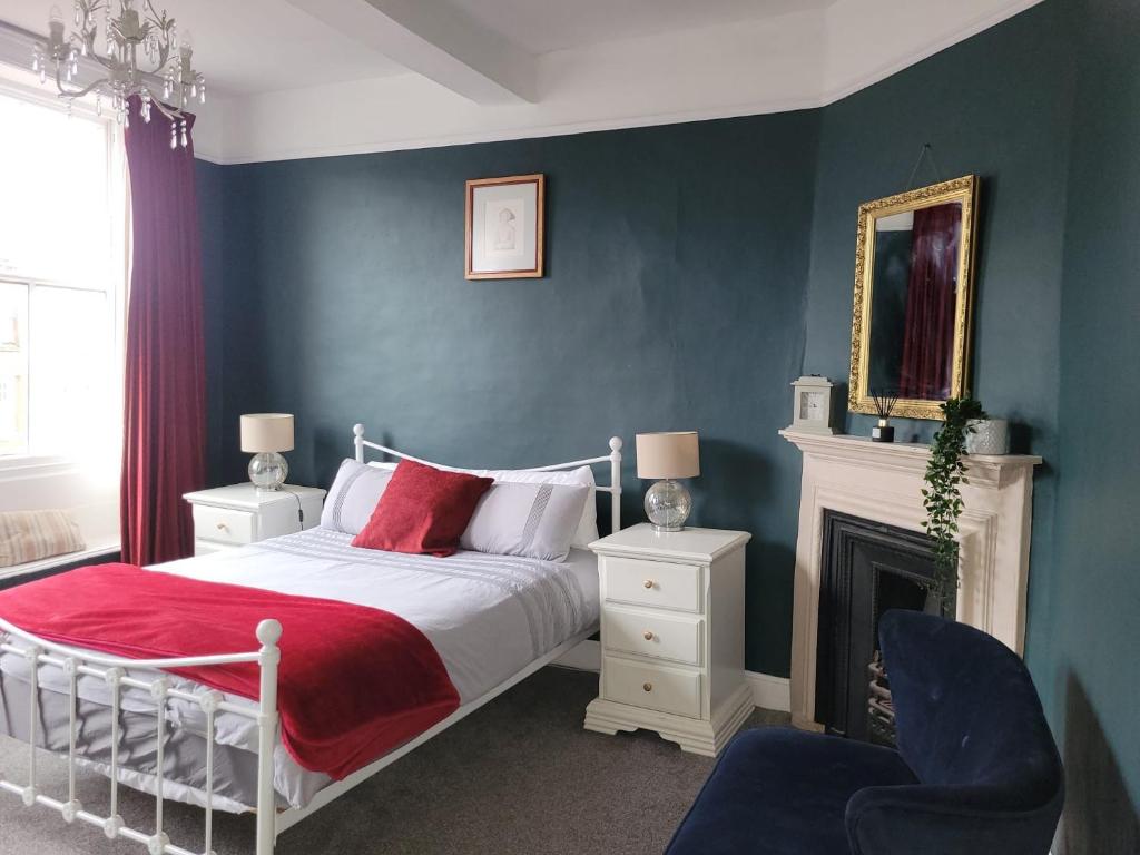a bedroom with a white bed and a fireplace at The Gingernut in Ross on Wye