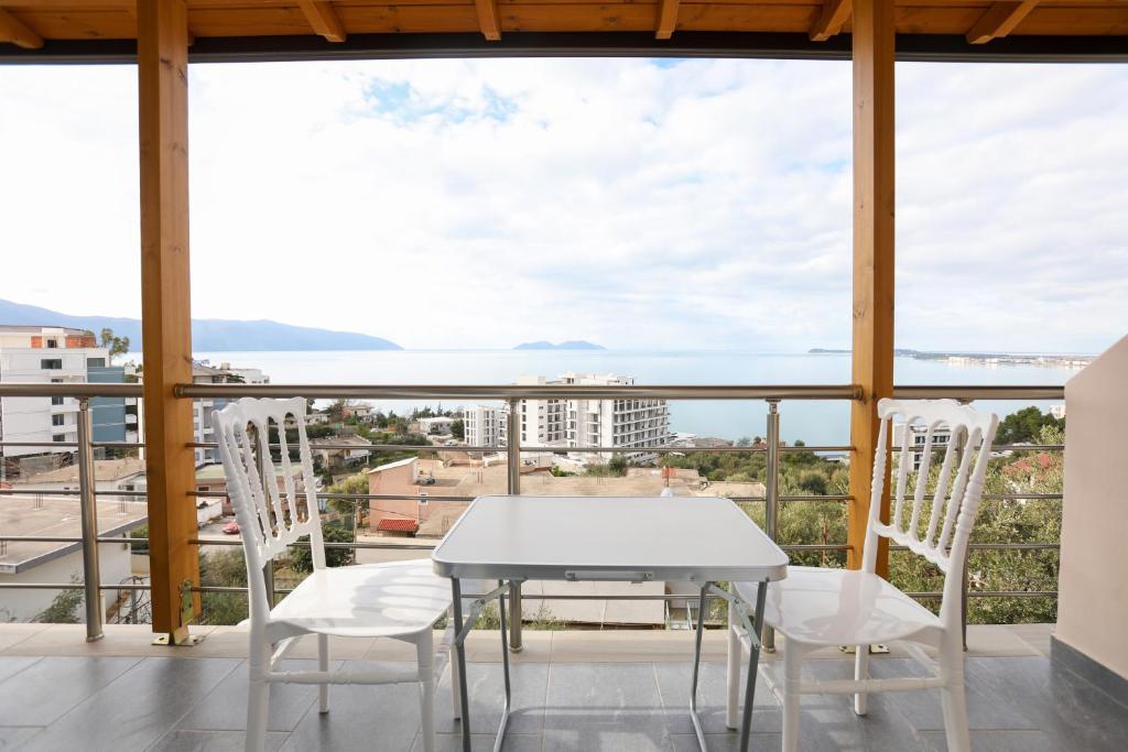 a white table and chairs on a balcony with a view at Villa Evelyn Free Parking in Vlorë