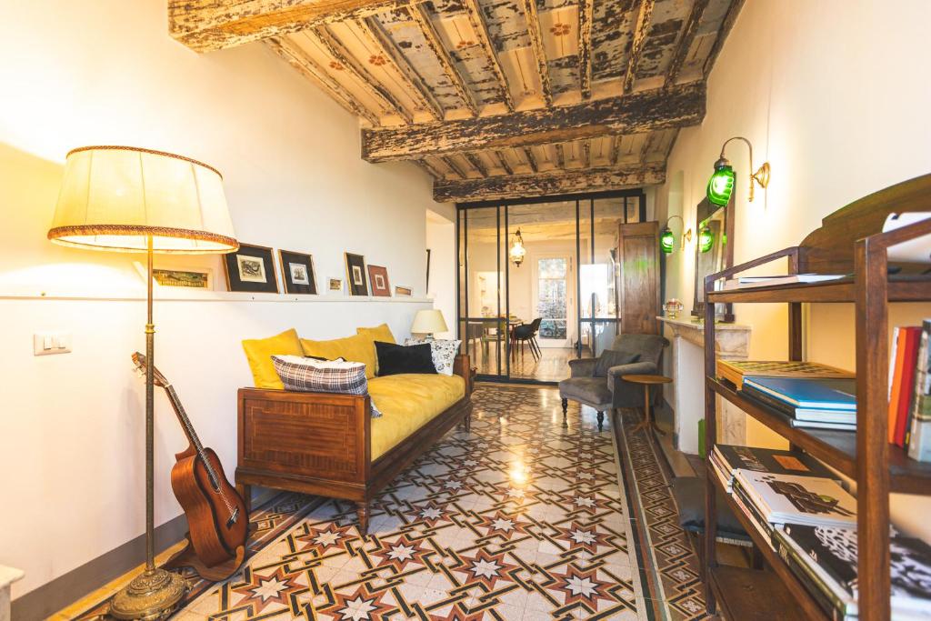 a living room with a bed and a couch and a guitar at Collazzi 15 in Montepulciano