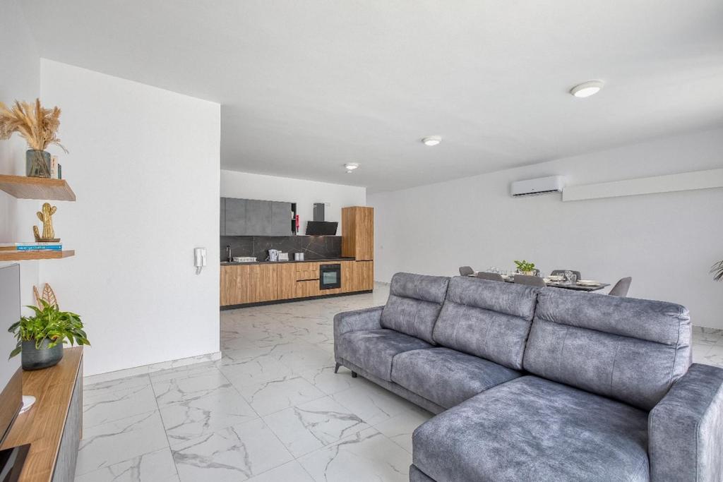 a living room with a couch and a kitchen at New Family-Friendly & Spacious Apartment by SF Homes in Fgura