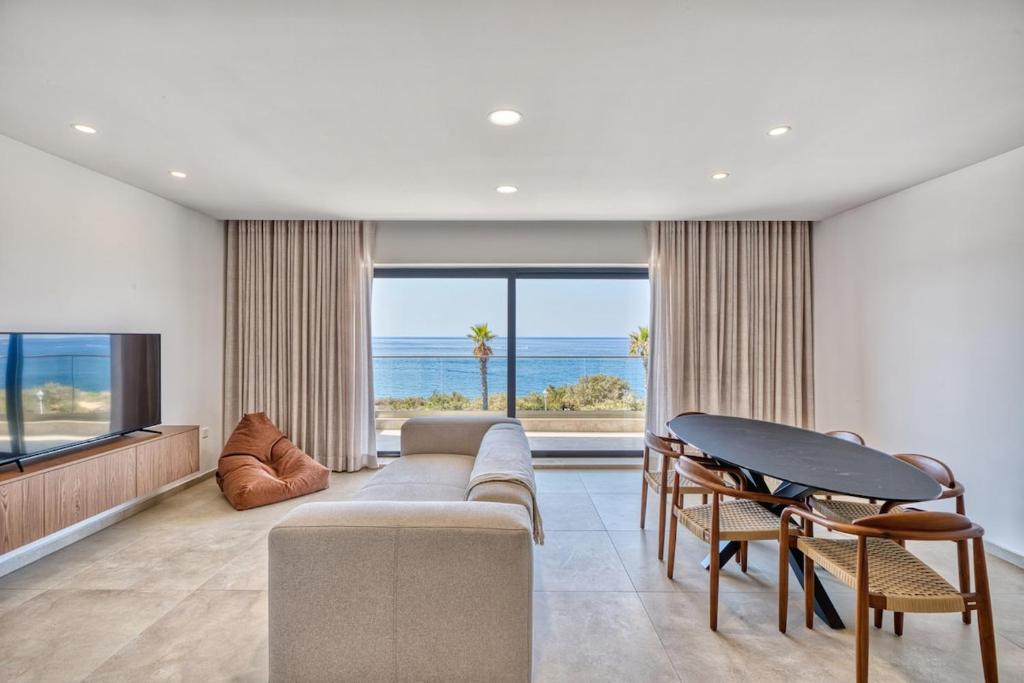 a living room with a couch and a large window at Seafront 3 Bedroom Luxury Getaway in St. Paul's Bay