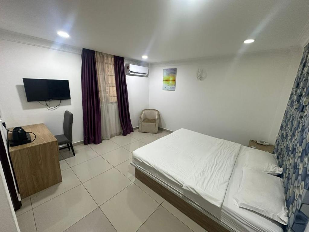 a bedroom with a bed and a desk and a television at Poorna Hotel at Jalan Ipoh Sentul Kuala Lumpur in Kuala Lumpur