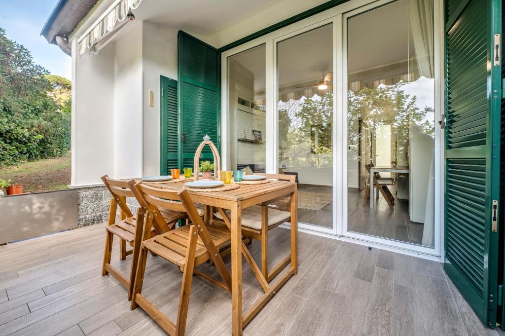 a kitchen with a wooden table and chairs on a patio at 070 - Villa OLANDA con veranda VISTA MARE a 5 minuti SPIAGGIA con PISCINA CONDOMINIALE in Sestri Levante