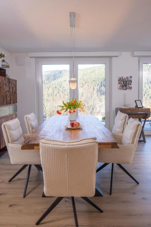 a dining room with a wooden table and chairs at Buhlbach, Black Forest Retreat, mit Sonnenterrasse in Baiersbronn