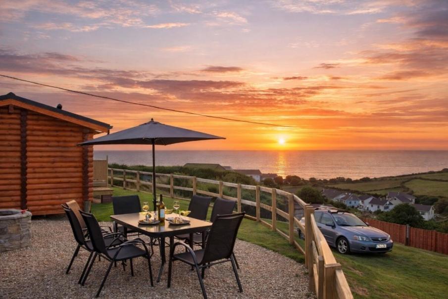 a table with chairs and an umbrella and a car at CROYDE RANCH CHALET 2 Bedrooms in Croyde