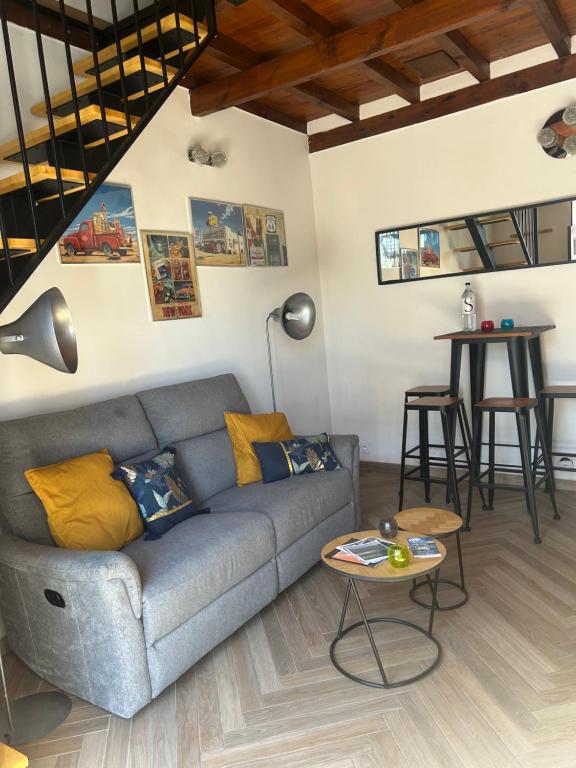 a living room with a couch and a table at Triplex Hyper Centre Bastia Direct Musée et Citadelle in Bastia