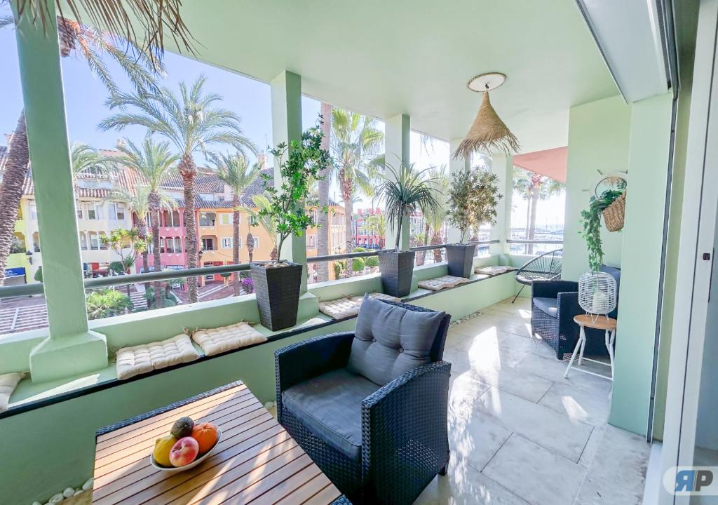 a balcony with a table and chairs and palm trees at Apartamento Deluxe Sotogrande in San Roque