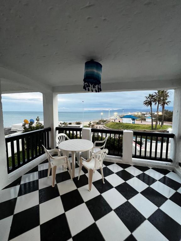 a porch with a table and chairs on a checkered floor at CHY dreams in Cabo Negro